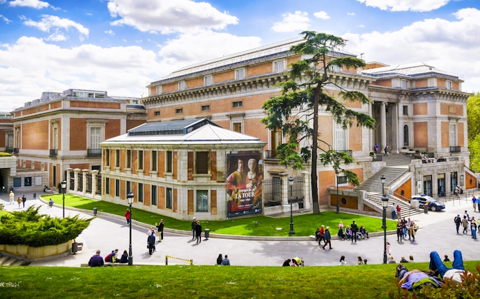 Prado Museum exterior with visitors in Madrid, Spain.