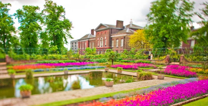 Kensington Palace gardens with vibrant flowers and reflecting pool.