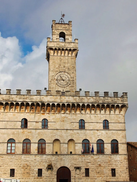 Palazzo Comunale in Montepulciano, Tuscany, Italy, under a cloudy sky.