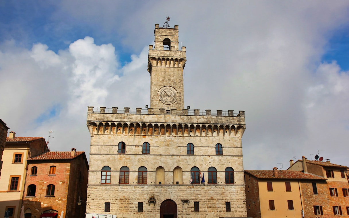 Palazzo Comunale in Montepulciano, Tuscany, Italy, under a cloudy sky.