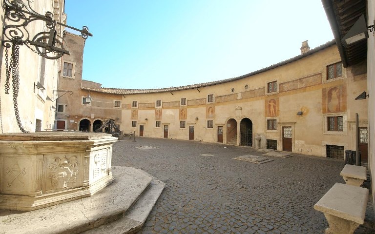 Courtyard inside Castel Sant'Angelo, Rome, with historic frescoes and stone architecture.