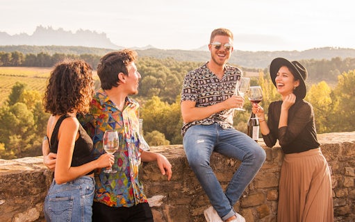 Group enjoying wine on Montserrat walking tour with scenic vineyard view.