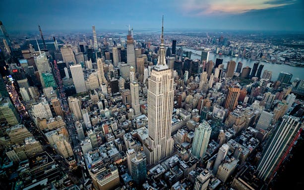 Aerial view of New York City skyline featuring the Empire State Building during a helicopter tour.