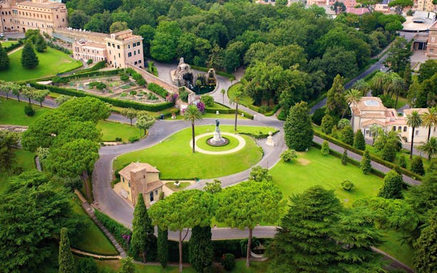 Vatican Gardens aerial view with lush greenery and historic buildings, Rome, Italy.