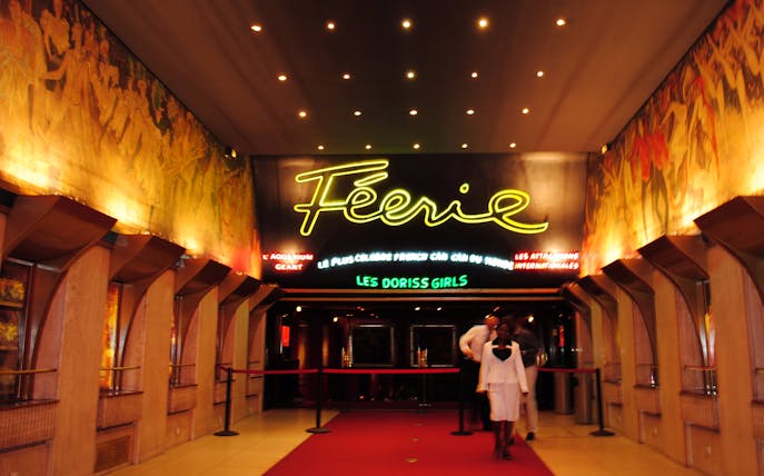 Entrance to Moulin Rouge in Paris with neon sign and red carpet.