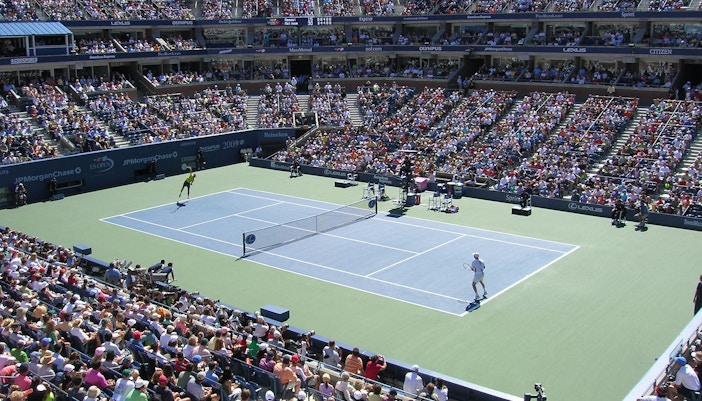US Open Tennis Championship, Round 2 match in progress at a packed stadium.