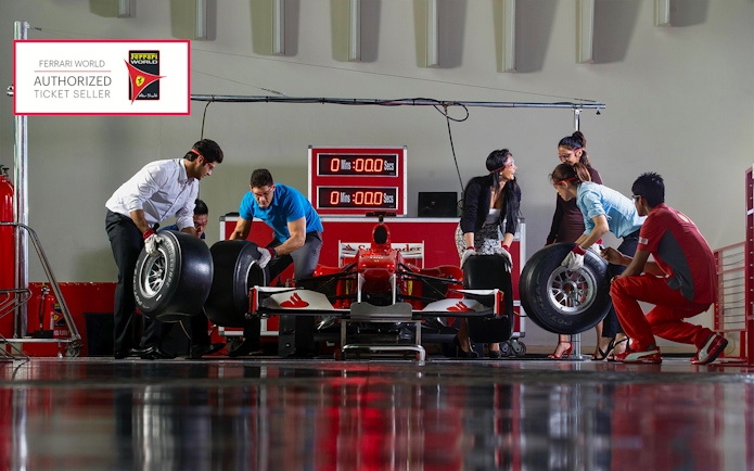 Ferrari World Abu Dhabi pit stop experience with visitors changing race car tires.