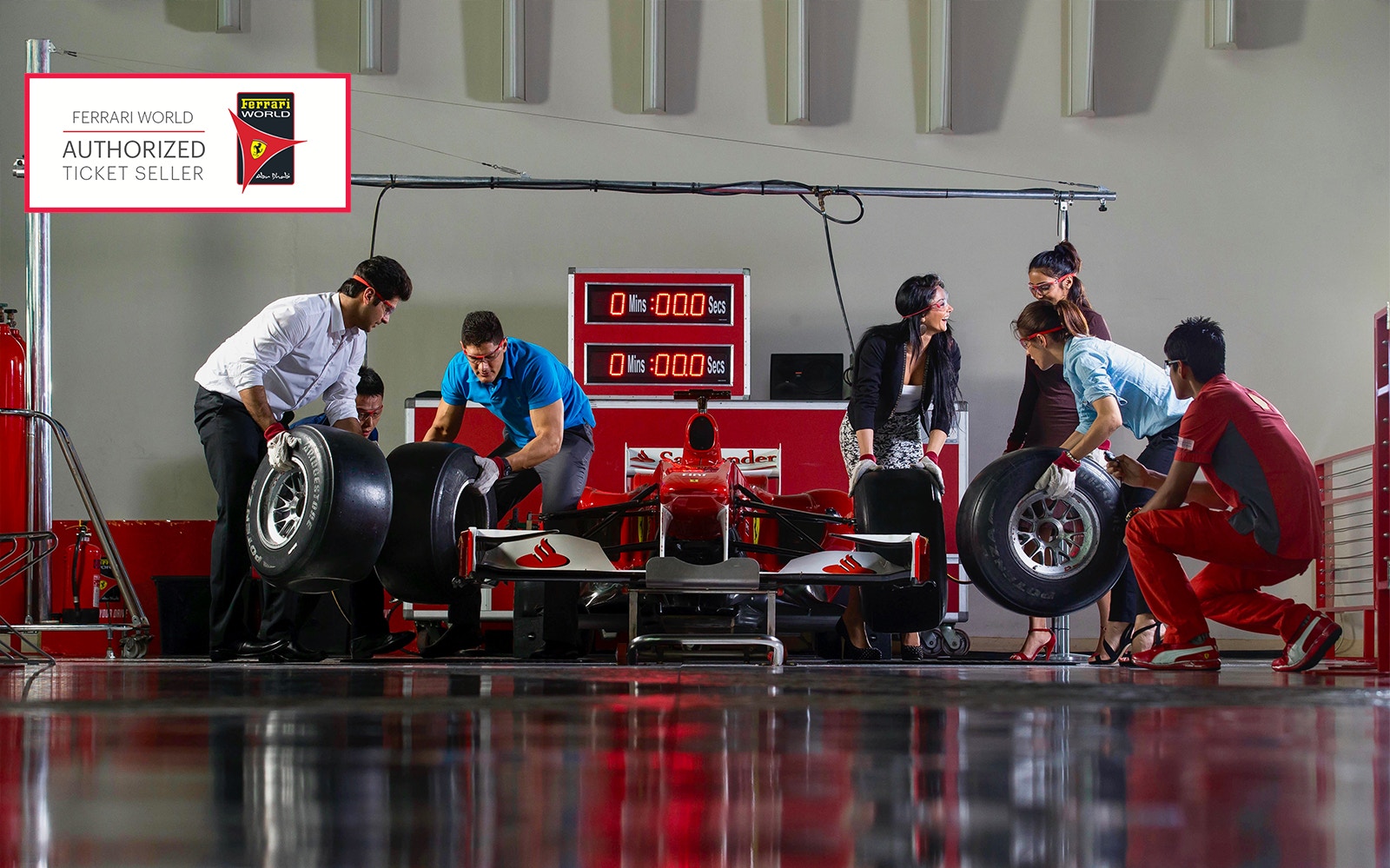 Ferrari World Abu Dhabi pit stop experience with visitors changing race car tires.