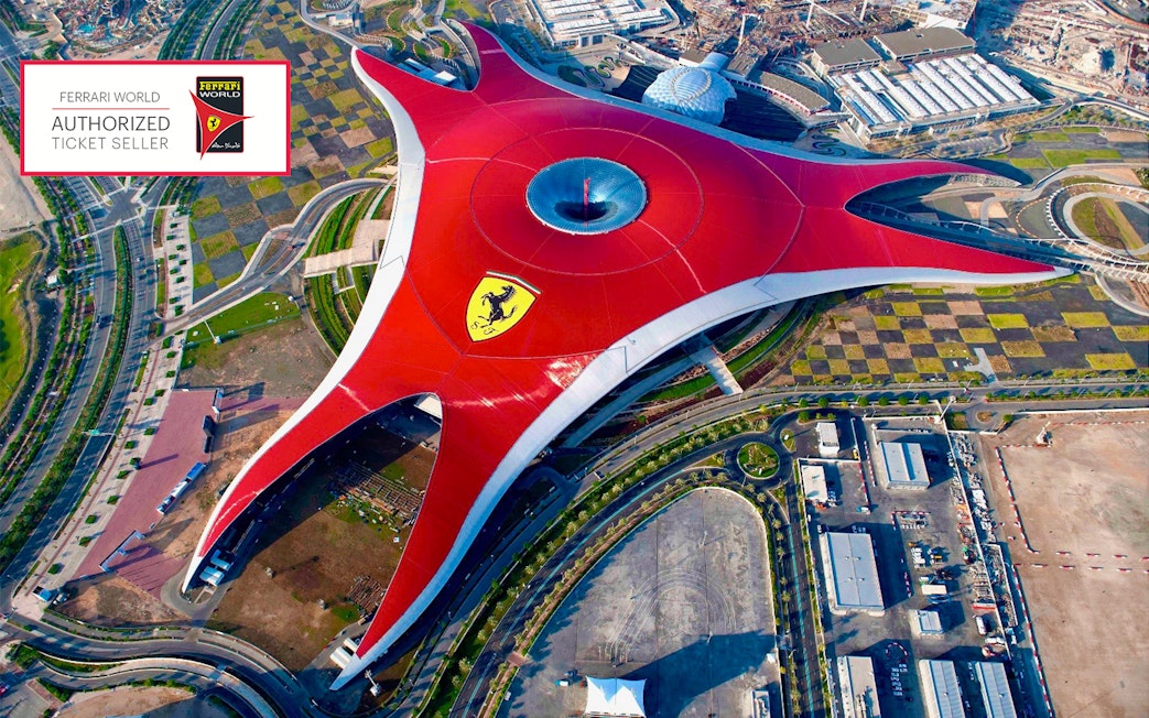 Aerial view of Ferrari World Abu Dhabi with its iconic red roof and surrounding landscape.