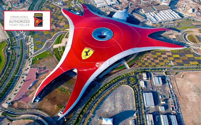 Aerial view of Ferrari World Abu Dhabi with its iconic red roof and surrounding landscape.