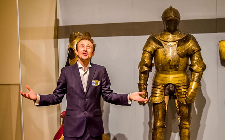 Tour guide presenting medieval armor at The MET during VIP Night Tour.