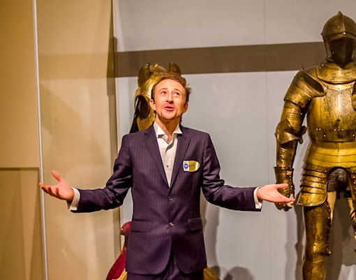 Tour guide presenting medieval armor at The MET during VIP Night Tour.