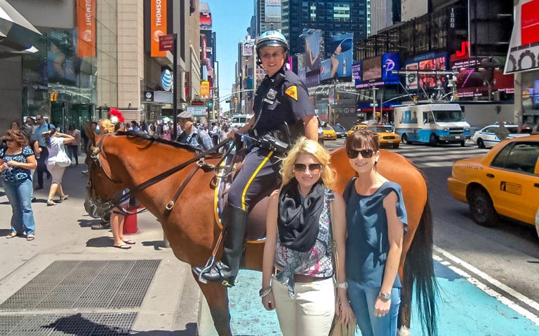 Mounted police officer in Times Square with tourists, part of Times Square & Greenwich Village Tour.