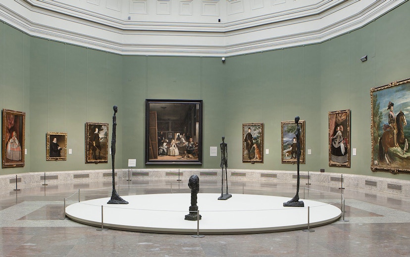Visitors viewing classic art exhibits at Prado Museum, Madrid, Spain.