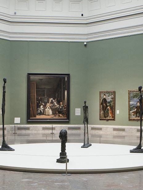 Visitors viewing classic art exhibits at Prado Museum, Madrid, Spain.
