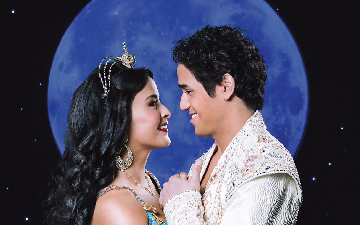 Two characters from Aladdin smiling at each other with a moonlit backdrop.
