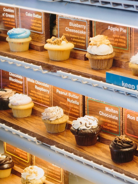 Cupcake display in New York bakery featuring various flavors for walking tour.