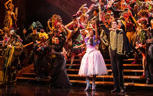 Performers in elaborate costumes on stage during Phantom of the Opera musical.