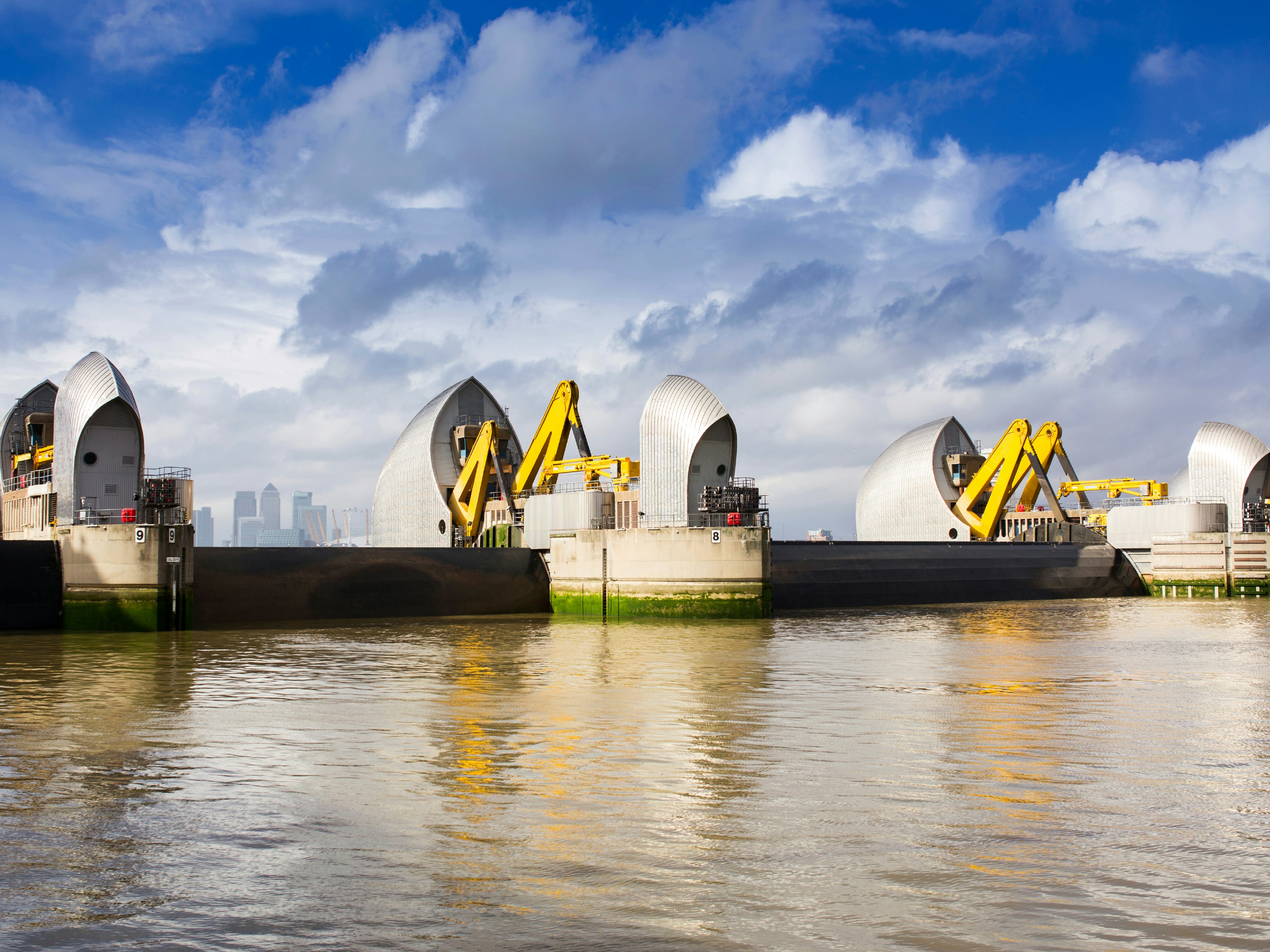 Thames Barrier on the River Thames with London skyline in the background.