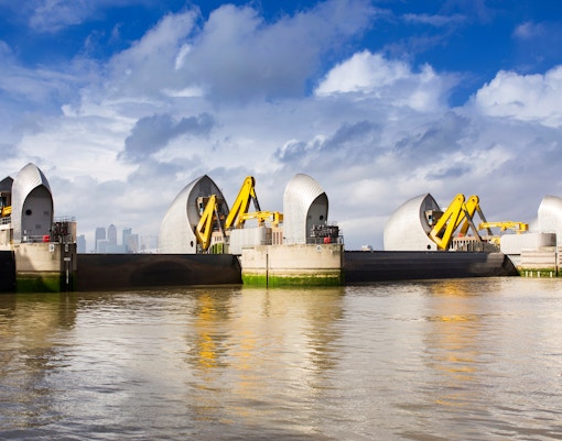 Thames Barrier on the River Thames with London skyline in the background.