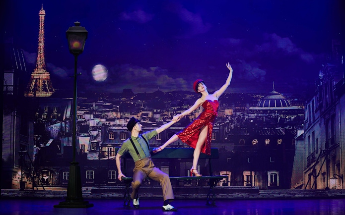 Dancers performing at Paradis Latin show in Paris with Eiffel Tower backdrop.