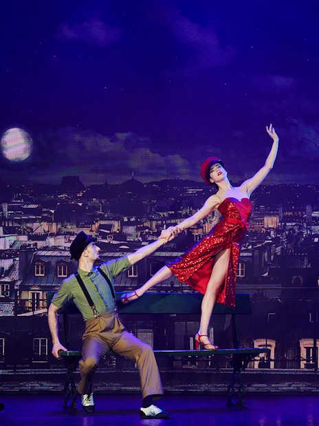 Dancers performing at Paradis Latin show in Paris with Eiffel Tower backdrop.