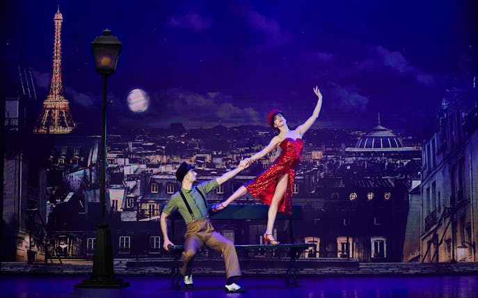 Dancers performing at Paradis Latin show in Paris with Eiffel Tower backdrop.