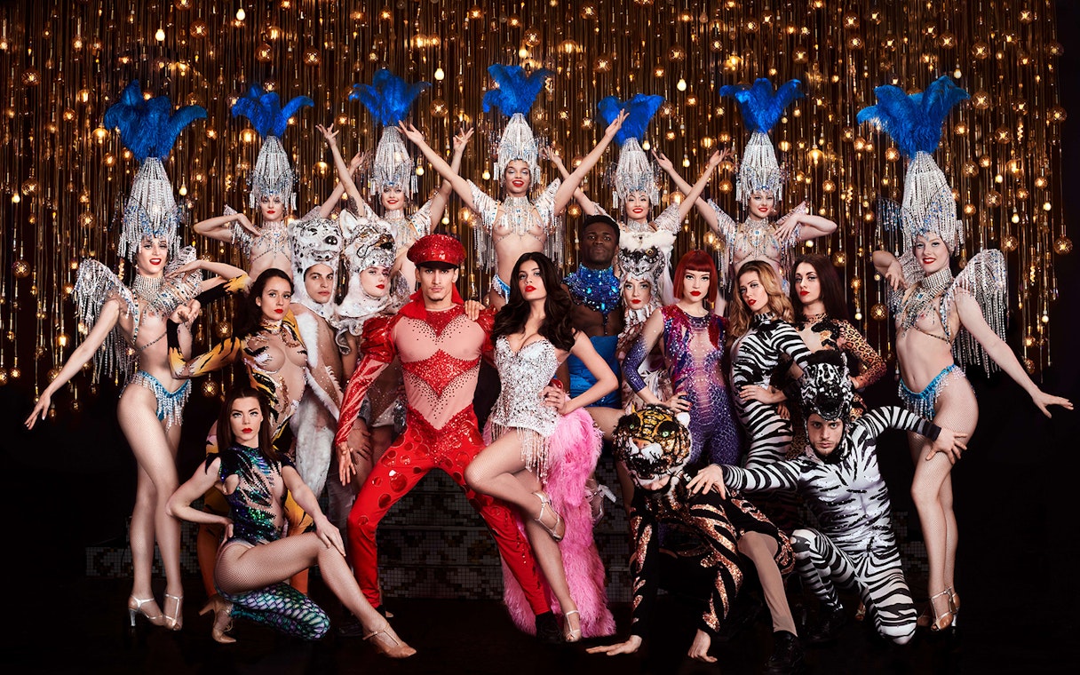 Performers in vibrant costumes at Paradis Latin cabaret show, Soirée Napoléon, Paris.