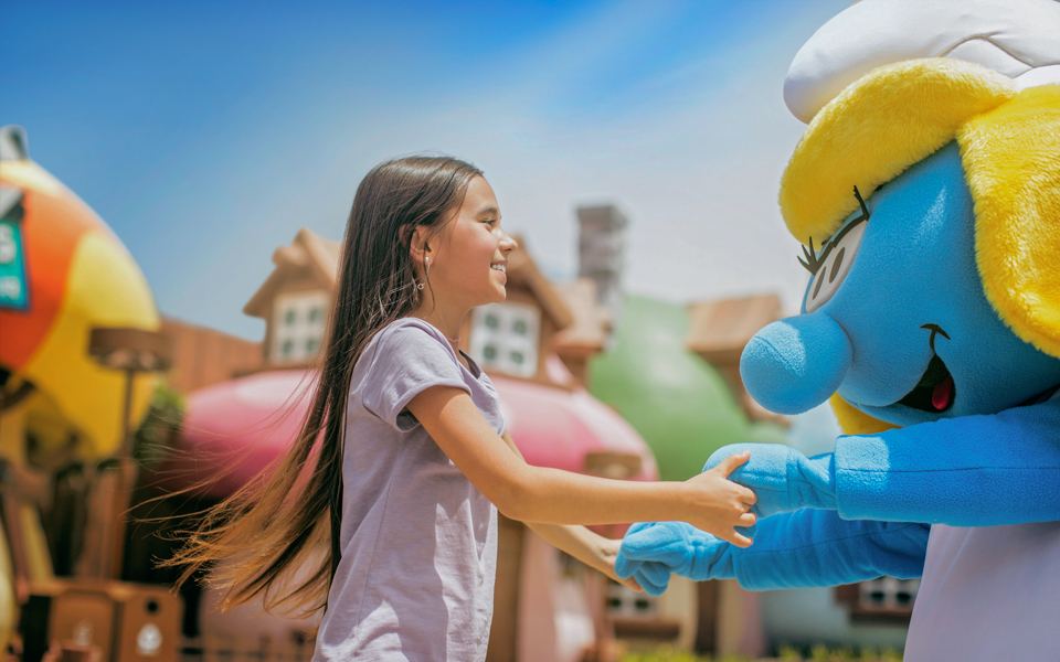 Girl meeting a Smurf character at MOTIONGATE™ Dubai.