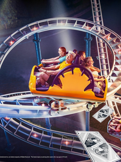 Roller coaster at MOTIONGATE Dubai "Now You See Me" ride with themed playing card decor.