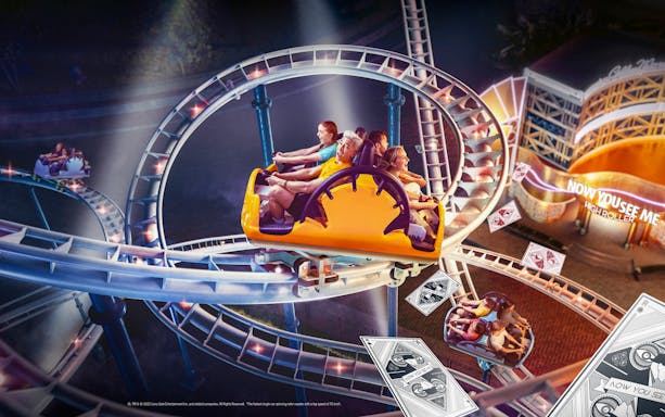 Roller coaster at MOTIONGATE Dubai "Now You See Me" ride with themed playing card decor.
