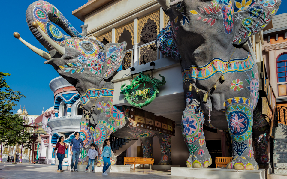 Colorful elephant statues at Dubai Parks and Resorts entrance with visitors walking nearby.