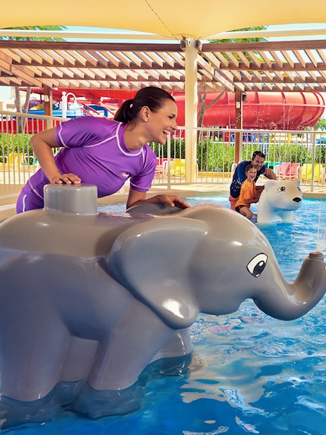 Child playing near elephant water feature at LEGOLAND Water Park Dubai.