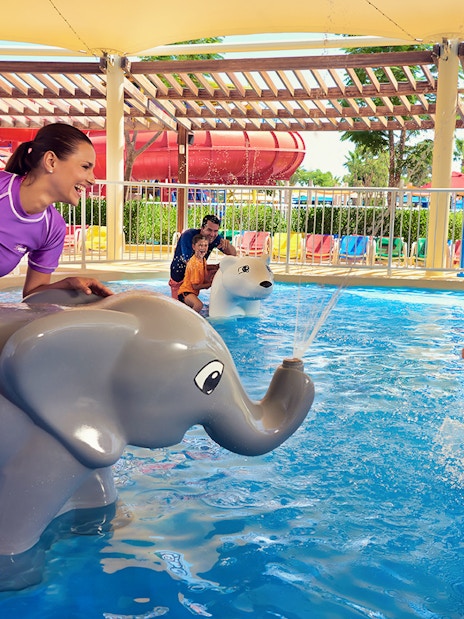 Child playing near elephant water feature at LEGOLAND Water Park Dubai.