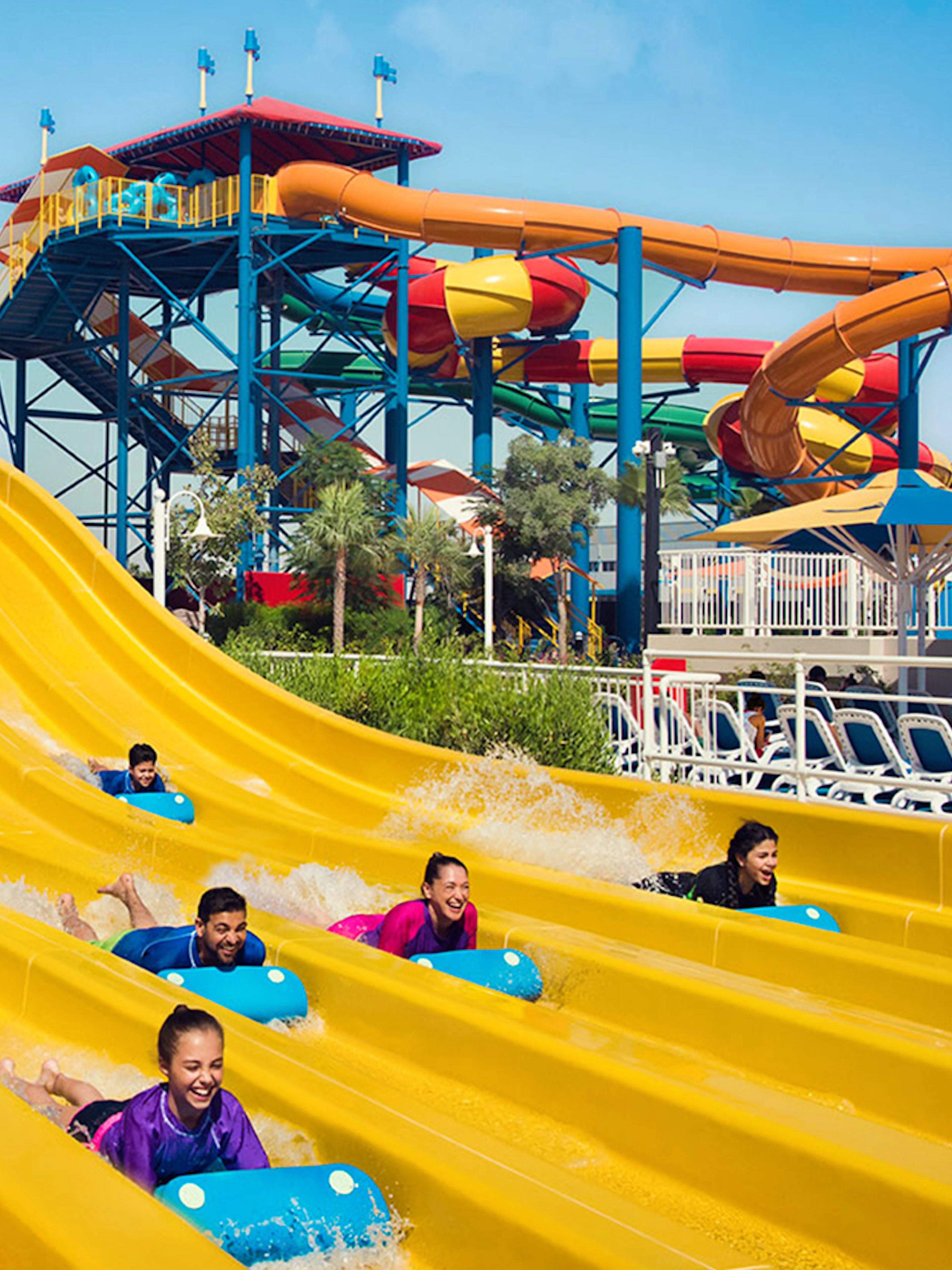 Visitors enjoying colorful water slides at LEGOLAND Water Park Dubai, part of combo with Dubai Safari Park.