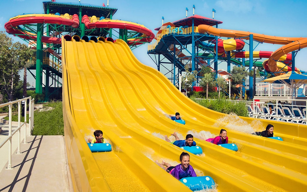 Visitors enjoying colorful water slides at LEGOLAND Water Park Dubai, part of combo with Dubai Safari Park.