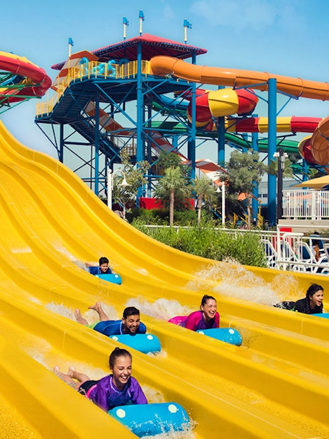 Visitors enjoying colorful water slides at LEGOLAND Water Park Dubai, part of combo with Dubai Safari Park.