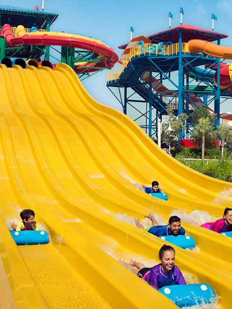 Visitors enjoying colorful water slides at LEGOLAND Water Park Dubai, part of combo with Dubai Safari Park.