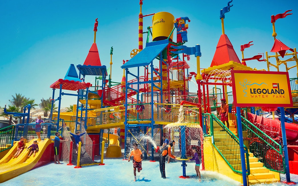 Children playing at LEGOLAND® Dubai Water Park with colorful slides and water features.