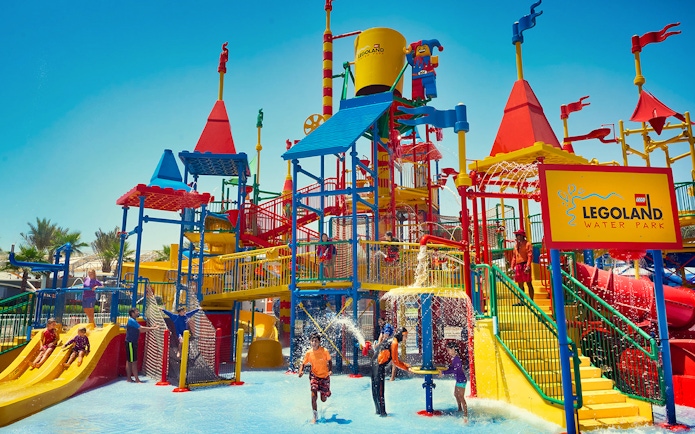 Children playing at LEGOLAND® Dubai Water Park with colorful slides and water features.