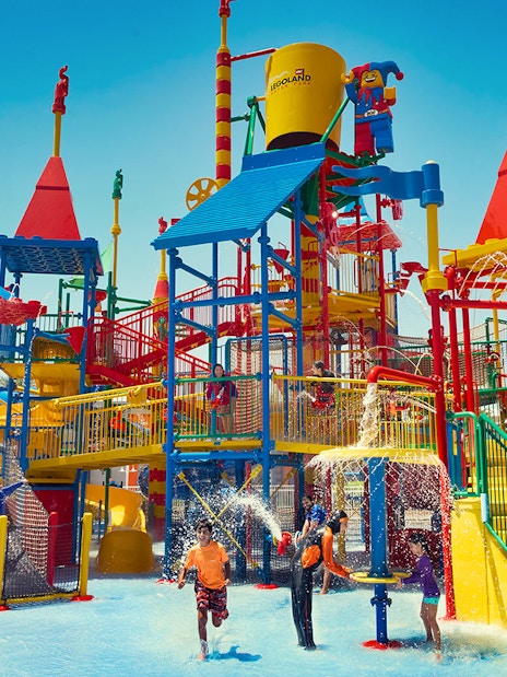 Children playing at LEGOLAND® Dubai Water Park with colorful slides and water features.