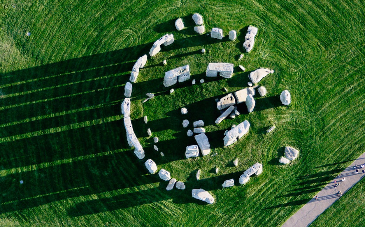 Aerial view of Stonehenge stone circle on a grassy field, part of a day trip from London.