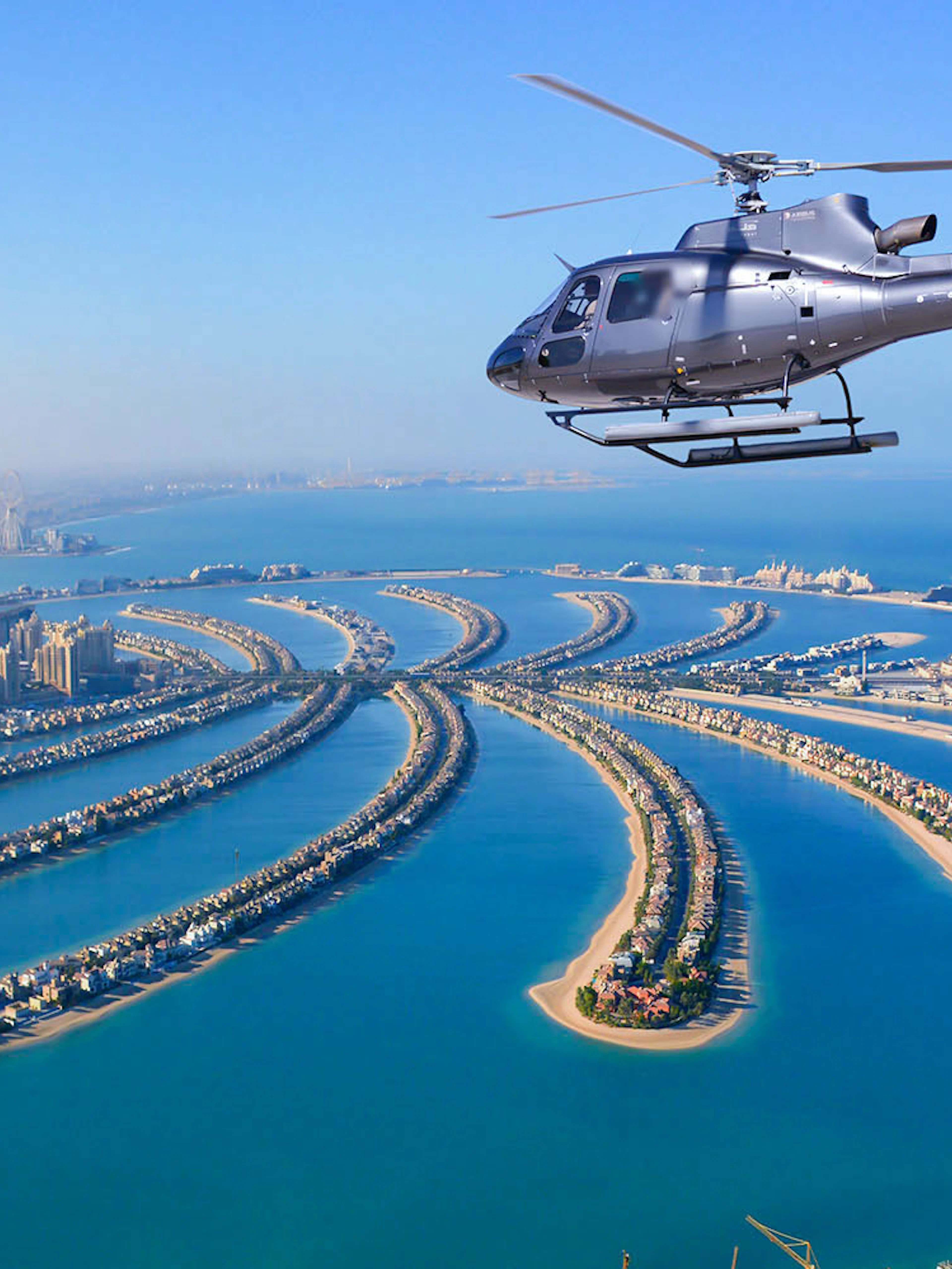 Helicopter flying over Palm Jumeirah, Dubai during Odyssey Helicopter Private Tour.