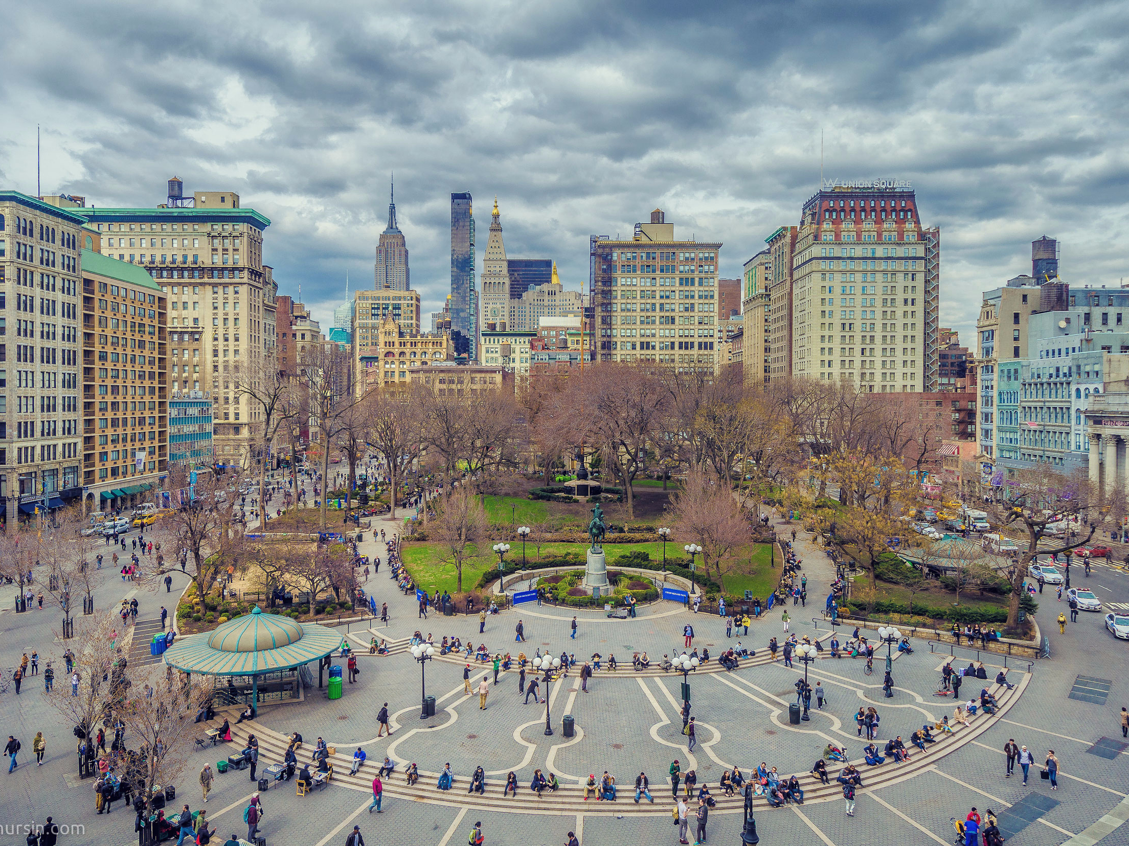 Union Square in New York City with surrounding buildings and people walking.