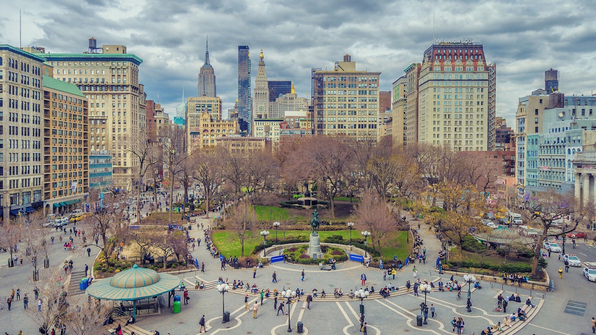 Union Square in New York City with surrounding buildings and people walking.