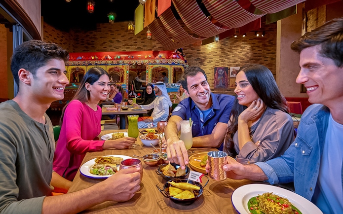 Group dining at IMG Worlds of Adventure restaurant, enjoying diverse cuisine.