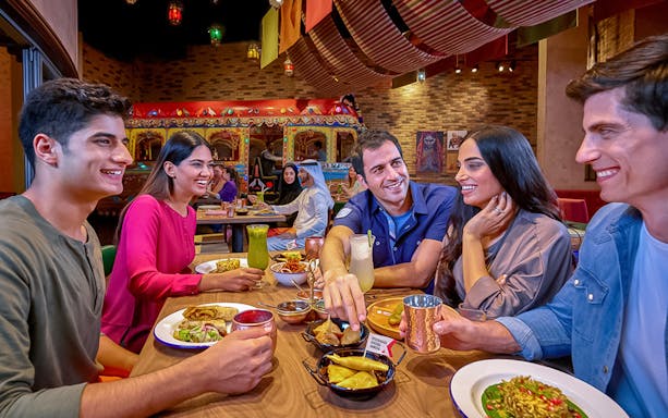 Group dining at IMG Worlds of Adventure restaurant, enjoying diverse cuisine.