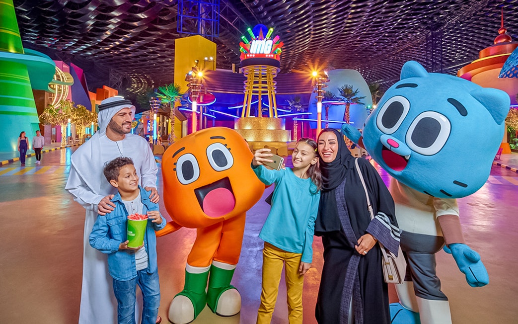 Family taking a selfie with cartoon characters at IMG Worlds of Adventure, Dubai.
