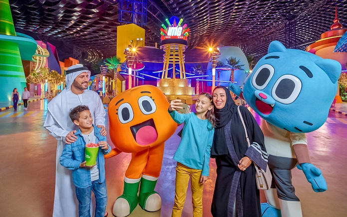 Family taking a selfie with cartoon characters at IMG Worlds of Adventure, Dubai.