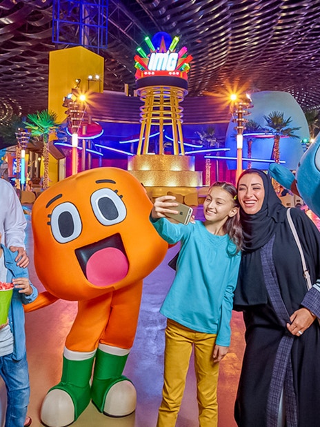 Family taking a selfie with cartoon characters at IMG Worlds of Adventure, Dubai.